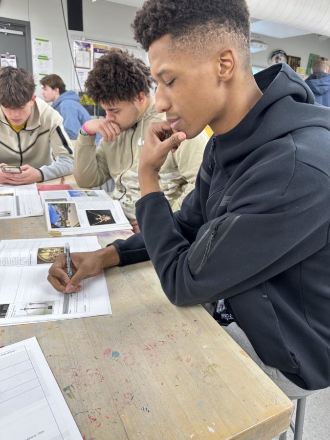 Landon Edwards is taking notes on chapter three in Art Appreciation class on January 30th. Landon is a member on Norwalks basketball team who is on a nine game win streak. 