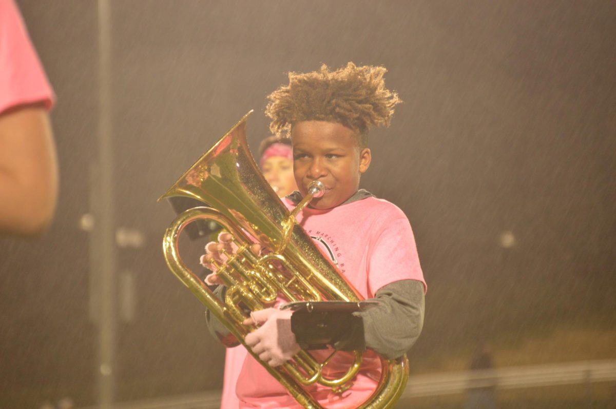 _ plays euphonium for the 8th grade marching band on Friday, Oct. 13. The band includes multiple brass instruments such as trumpet, trombone, and euphonium. 