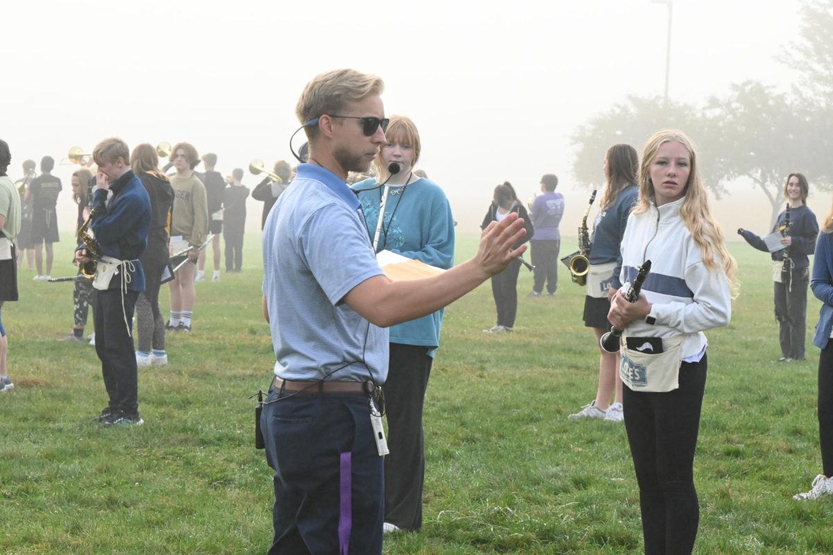 Marching band director Benjamin McCartney (left) makes sure everyone is in the right spot as Gracie Smith (left) and Brianna Havick watch on Sept. 28 at the marching band practice field, behind Norwalk High School. During marching band season, the marching band practices starting at 7:30 am on Tuesdays, Wednesdays, and Thursdays. 

