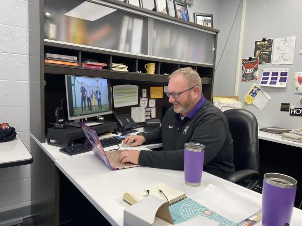 Norwalk High School Principal Chris Basinger works in his office on Nov. 28. “One thing that we do is we get pajamas for everybody, so when we get up next morning we’re all in our new Christmas pajamas,” he said.