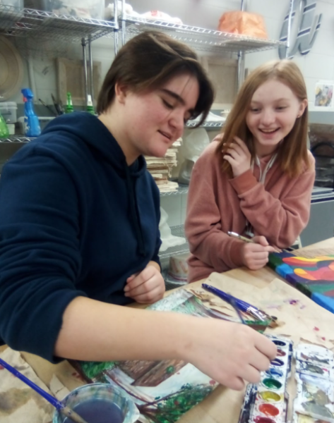 Rylee Campbell (left) and Emma Brenizer hold a conversation while working on projects for painting class on Tuesday, Dec. 19 in the art room. Campbell was working on a watercolor scene while Brenizer was working on an acrylic portrait painting. 