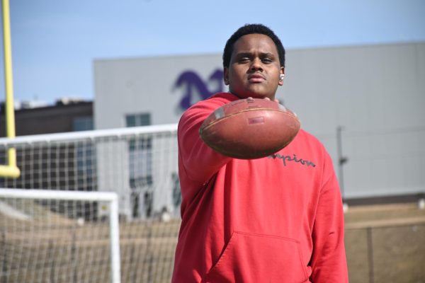 Abdi Ahmed poses with a football during PE class on Tuesday, Feb. 27, at the Norwalk football field. Ahmed said he shows his enjoyment of football during PE class.
