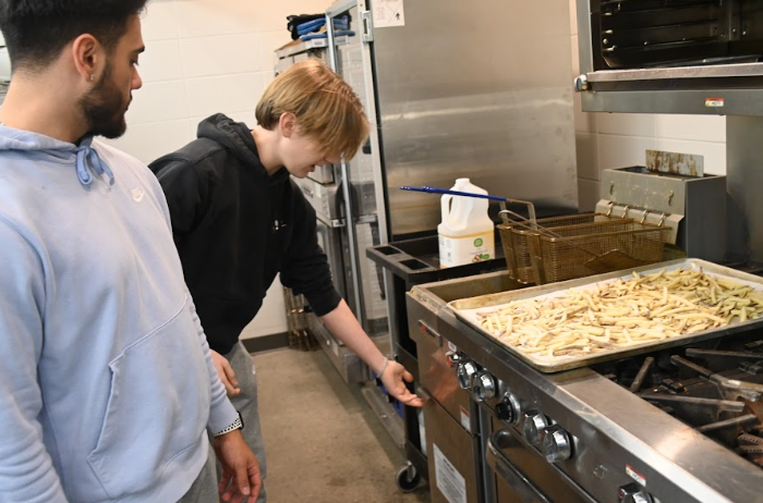 Gage Smith (left) and Parker Wood work at the fry station. At the Warrior Cafe, students work at actual restaurant stations, such as the fry station, management station, grill station, and saute station.