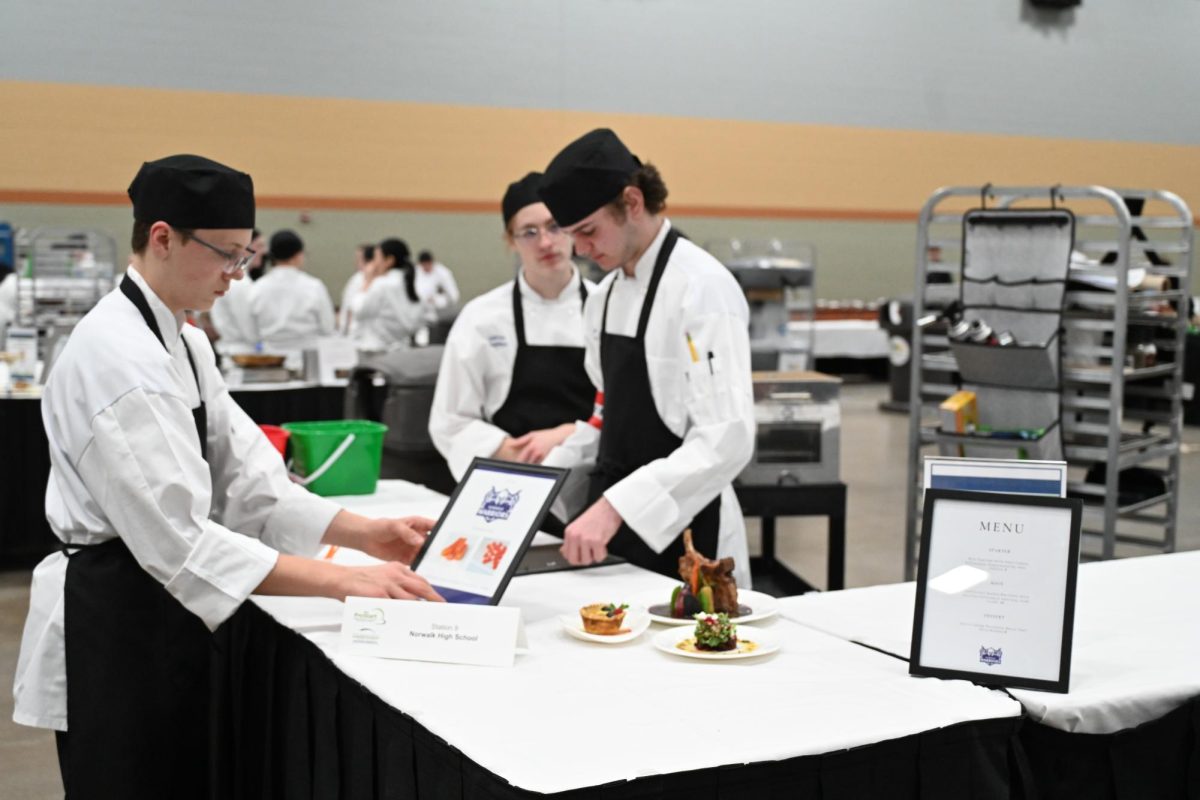 Sophomore Conner Emswiler (left), sophomore Sabrina Hautekeete, and junior Keegan Johnson, who is team captain, compete on Feb. 27, 2024 at the ProStart state competition at HyVee Hall. The Norwalk ProStart team won fourth place in the competition.