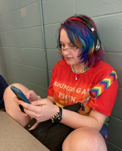 Ash Shelledy reads on their phone as they eat lunch in the cafeteria on May 21. They like to read and are planning to participate in  the summer reading program this summer. 