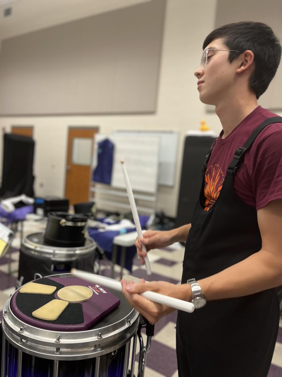 Junior Carson Menke warms up on the snare drum in the band room before the Warriors' marching band performance Friday night on Aug. 30. The band's halftime performance was their first of the season and was quoted by sophomore flute player Sylas Palladino as being "a great first show" for the band. 