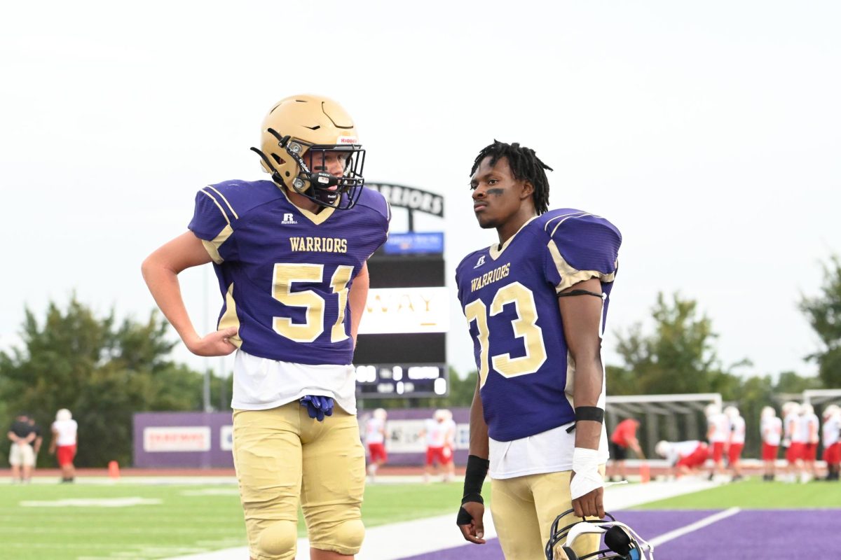 Juniors Cayden Hirsch (left) and D'Eljay Austin have a talk before the game. Hirsch plays the Linebacker and Tight End positions on the team while Austin plays Running Back and Cornerback.