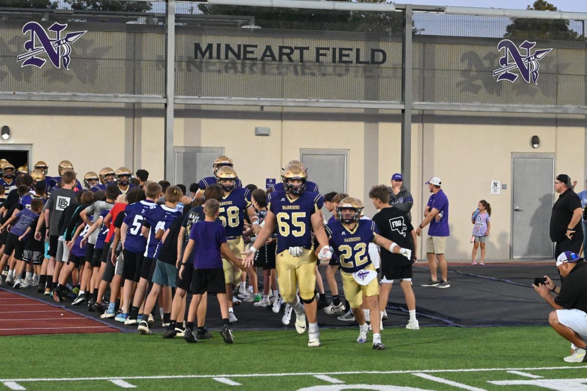 Carter Eden (left) and Dominic Tigner lead the Norwalk Football Team onto Mineart Field for the Homecoming football game against Newton on Friday, Sept. 13. Norwalk will face ADM at home on Friday, Sept. 20.