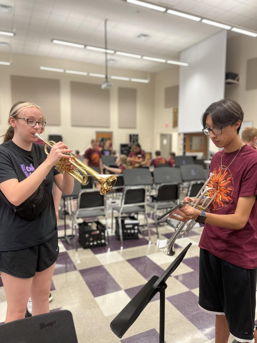 Seniors Allie Fuller (left) and Aaron Ramirez tune their trumpets before their banner performance of the National Anthem before the September 12th pep rally. The trumpets’ playing of the Star Spangled Banner is a staple of the marching band’s pregame performance.

