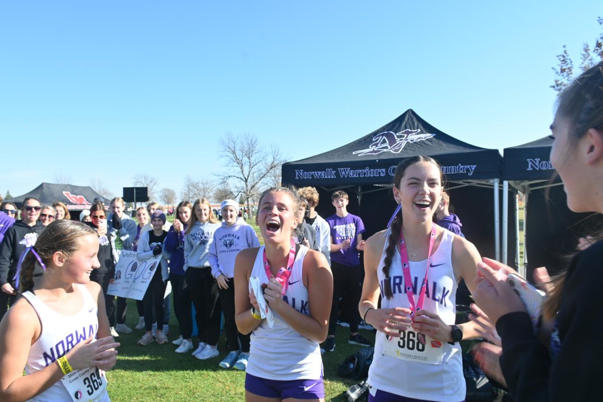 Freshmen, Grace Wetzler (left), Olive DeRocher, and Gabby Drymon celebrate at the girls' camp after the meet. 