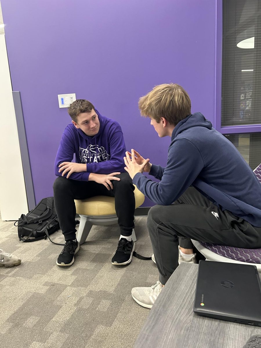 Seniors Jack Larson (left) and Jonah Sandhoff talk in the Norwalk High School library on Monday, Nov. 26. 