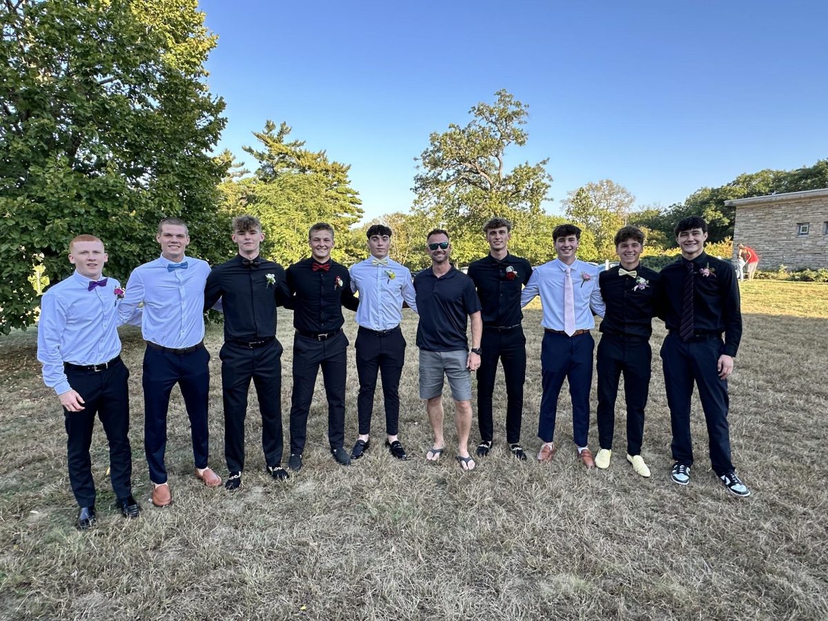Max Shallenberger (left), Kayden Frank, Xavier Bush, Brady Wilkening, Eli Robbins, Travis Hans, Ashton Hans, Kingston Lamb, Parker Cary, and Kale Wadle pose for a picture with everyone from their childhood baseball team the "Norwalk Nitro". 
