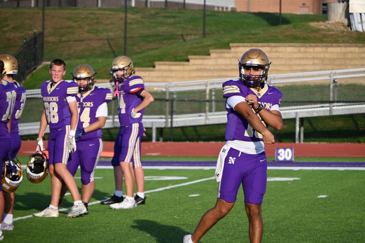 Abbas Mangel warms up by throwing before the game. Mangel plays the backup quarterback for the Norwalk varsity football team

