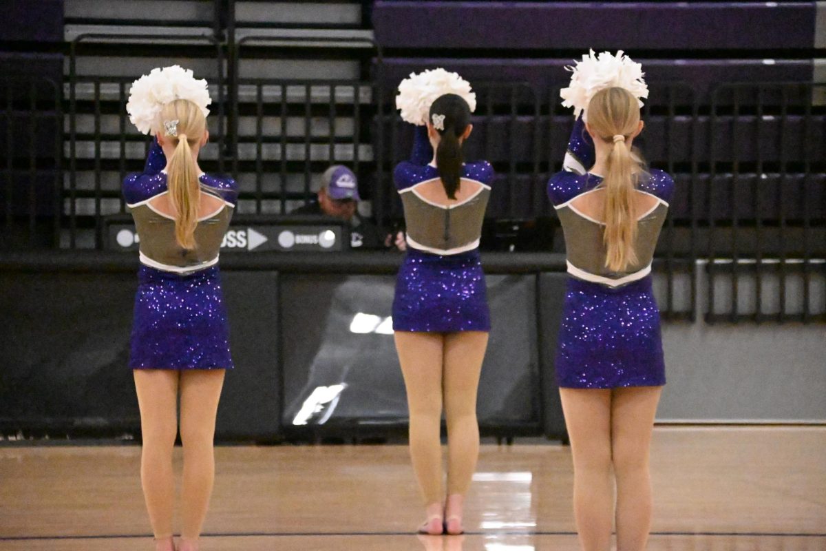 Freshman Lauren Pitts (left) gets ready to perform with juniors Abbie Kluender and Payten Woody at the Community Pep Rally on Thursday, Oct, 2. The dance team is performing a pom routine and preparing for State Dance on Friday, Dec. 6.