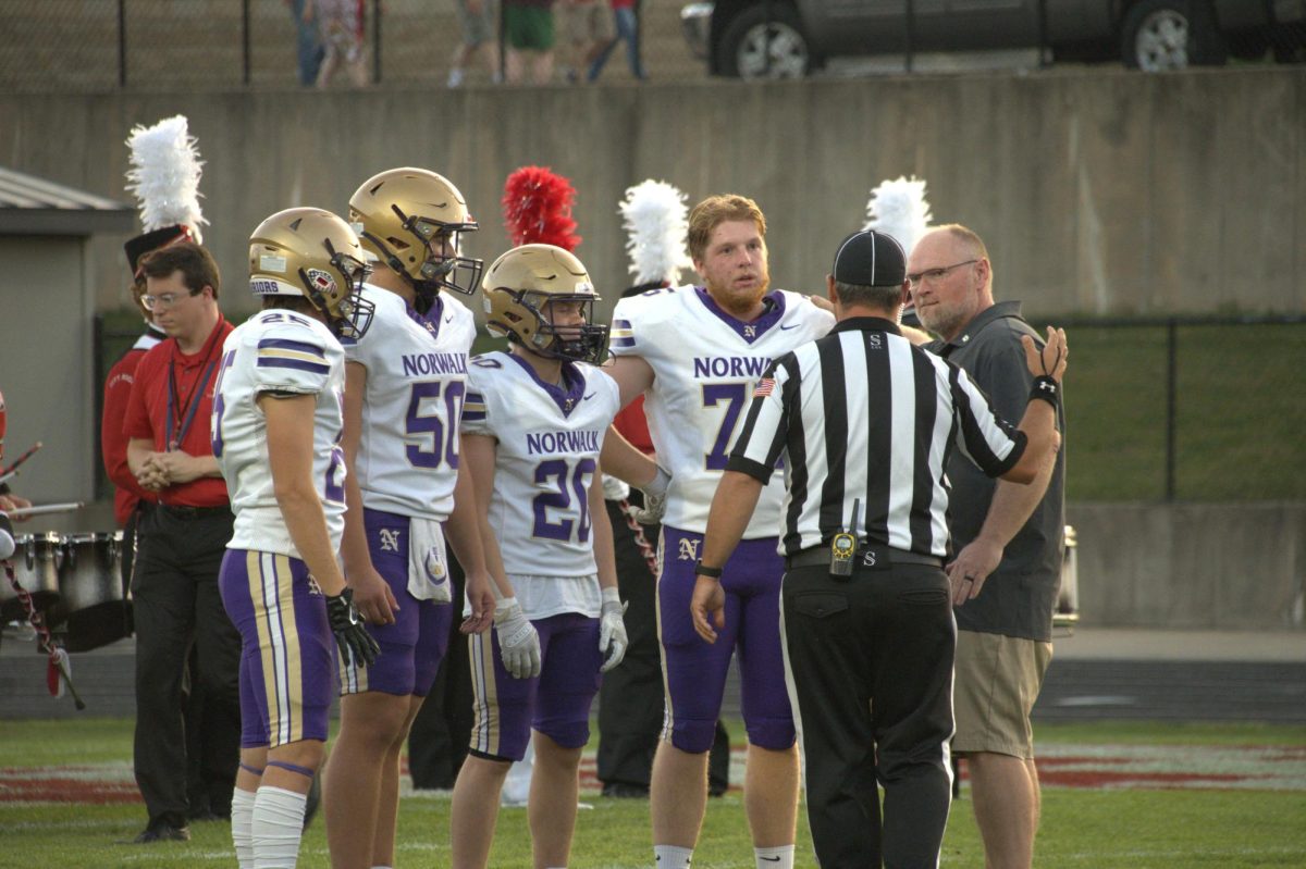 (From left) Cael Bemis, Penn Oppel, Breck Welch, and Owen Siemens talk with an official for the coin toss on Friday Sept. 26 at Iowa City. All the captains in this game were seniors.