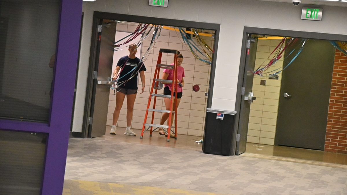 Katie Liedtke (left) and Addie Smith decorate the hallways for Homecoming Week on Friday, Sept. 26. The Homecoming dance will be at 7 p.m. Saturday, Oct. 4, in the North Gym.