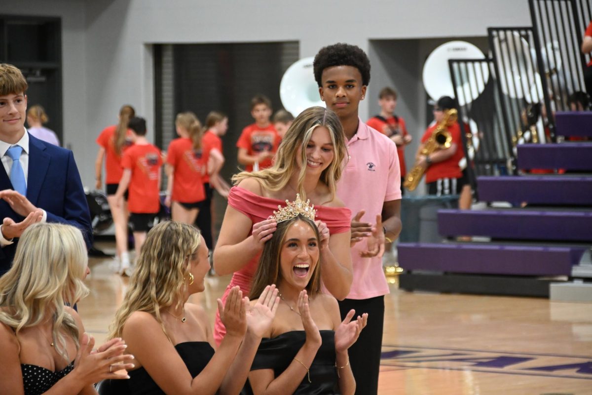 Senior Pearl Brown gets crowned Homecoming Queen by former queen Elizabeth Iverson at the Community Pep Rally. Pearl is involved in cross country, basketball, soccer, MVP, National Honor Society, Dance Marathon, show choir, and IHSAA student advisory council.