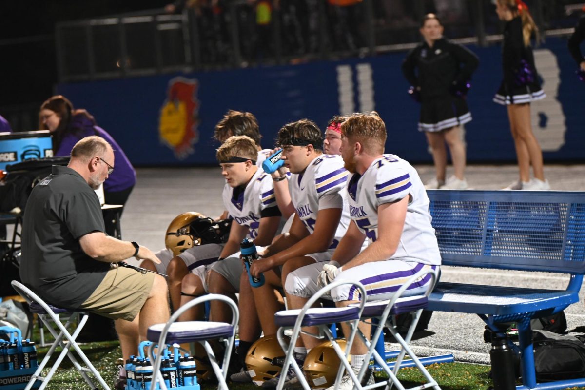 Coach Paul Patterson shows Breck Welch (left), Penn Oppel, and Owen Siemens the play on Oct. 17 during the game at Urbandale. The win against Urbandale was their 5th straight win of the season.