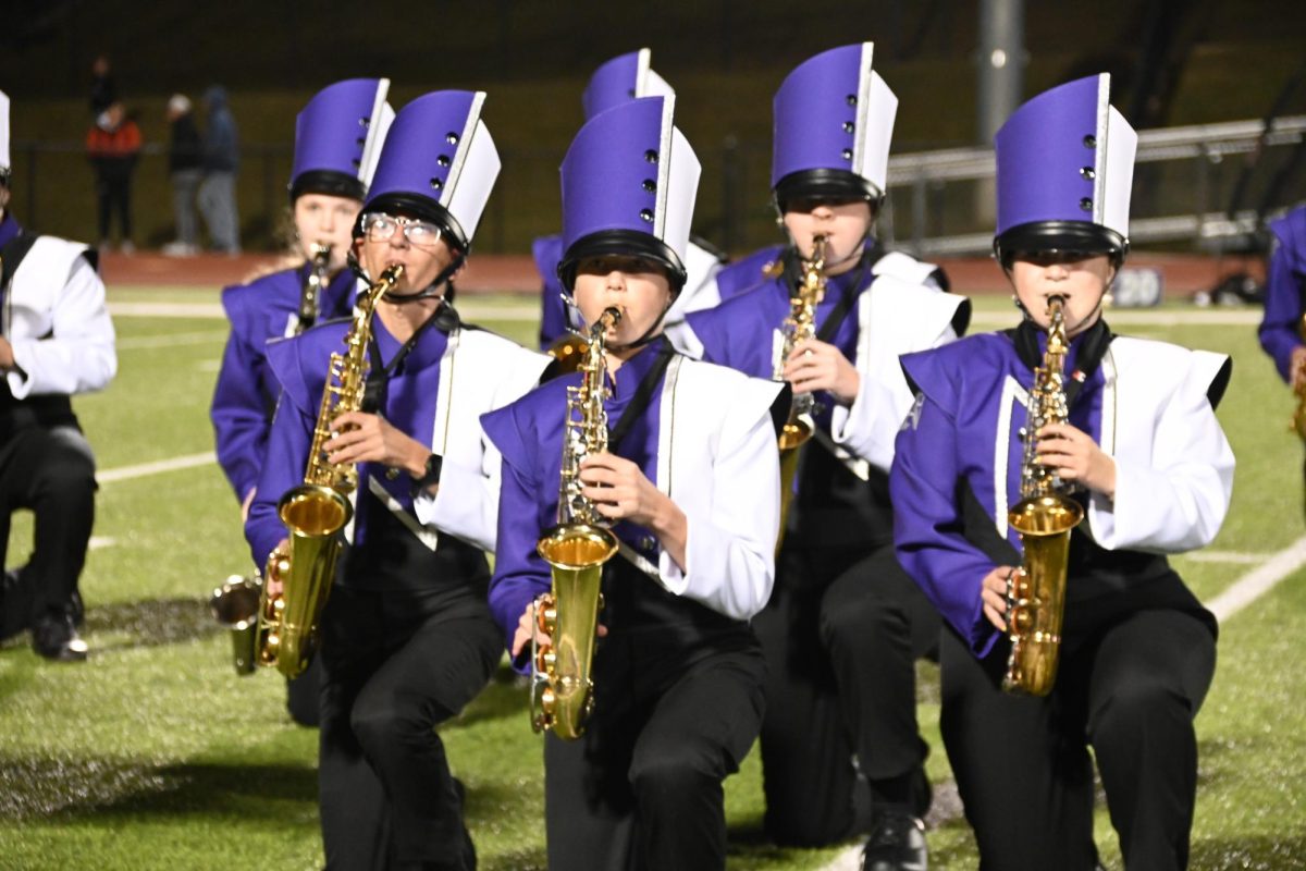The freshman saxophone group kneels during the third movement on Sept. 9, 2025. This was their first performance in front of the school.