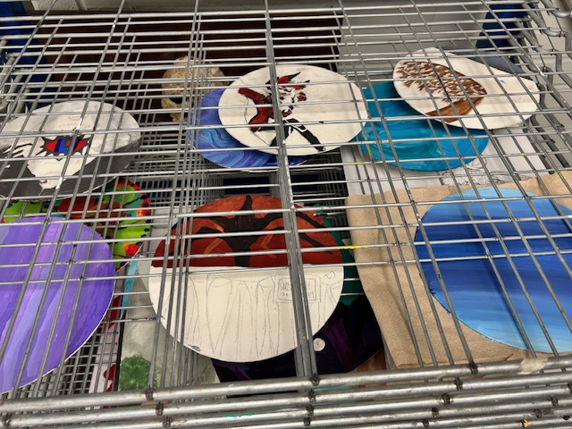 Wood plates dry on a rack after being painted by students at Art Club on Monday, Jan. 5, 2026. Art Club meets after school on Mondays, and everyone is welcome.
